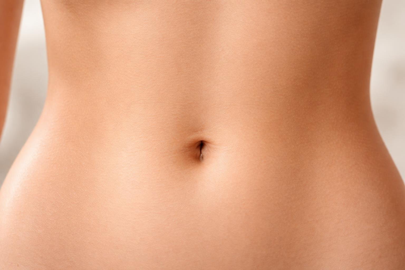 Close-up da região do umbigo de uma pessoa com pele limpa e saudável.